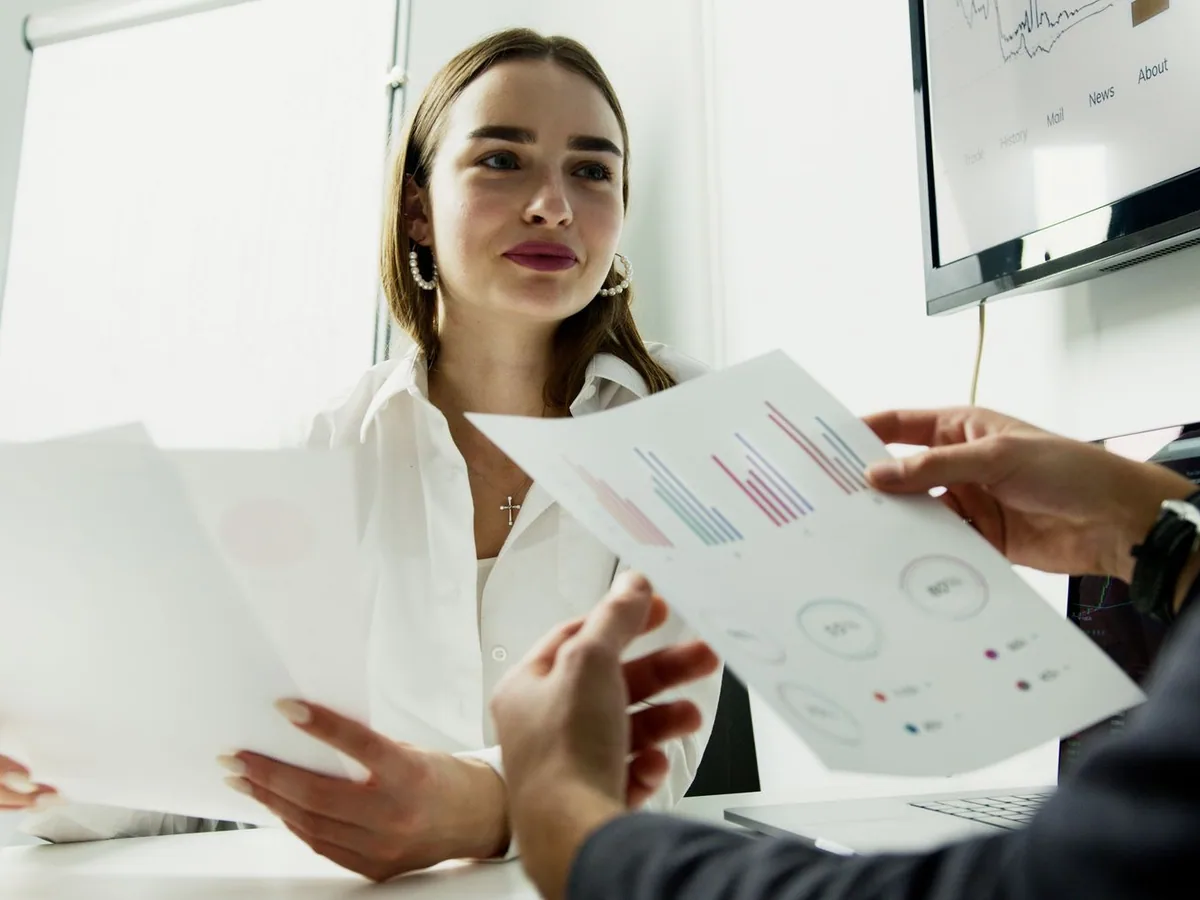 Illustrative stock photograph by Artem Podrez / Pexels Colleagues discussing printed reports around a meeting table