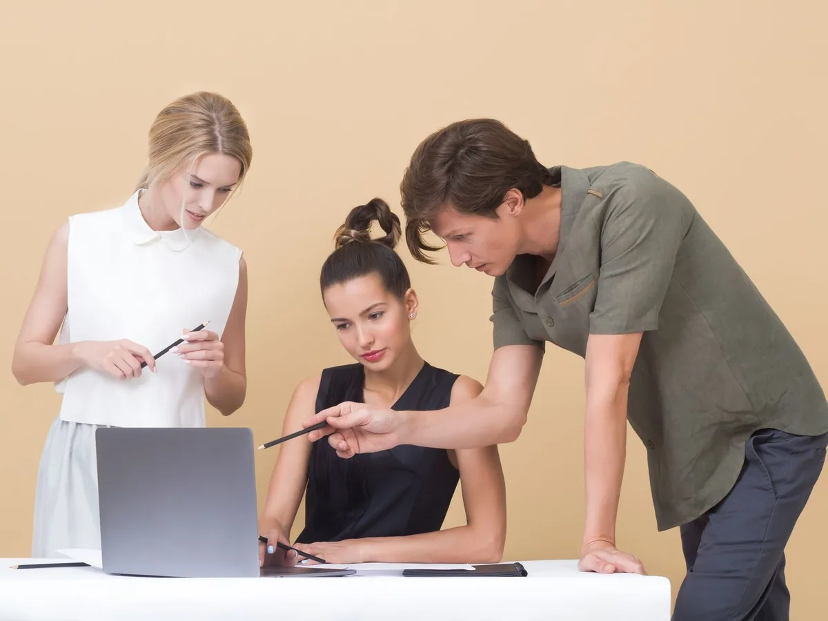 Colleagues sharing ideas while reviewing a laptop