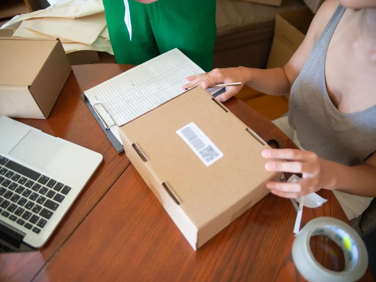 Small business owners preparing online orders beside a laptop