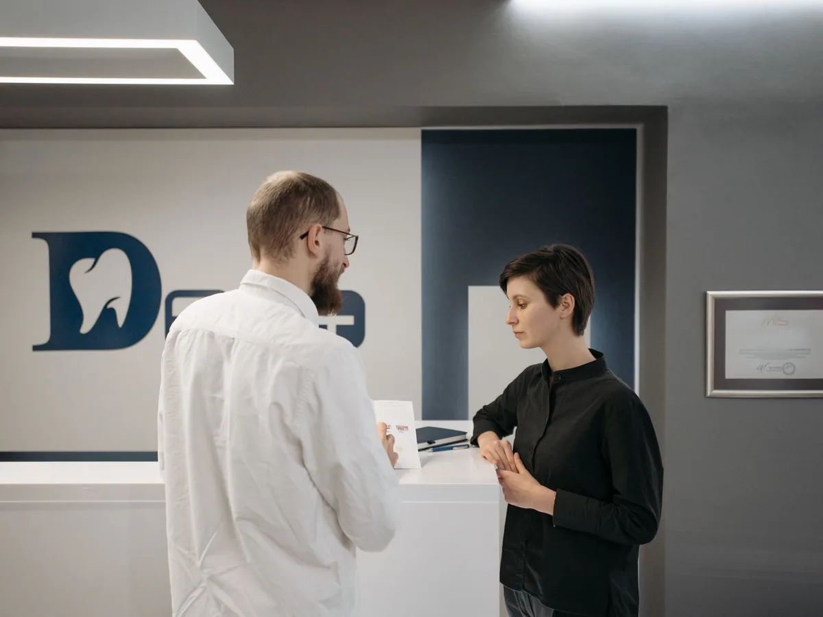 Dentist speaking with a visitor at a dental clinic reception