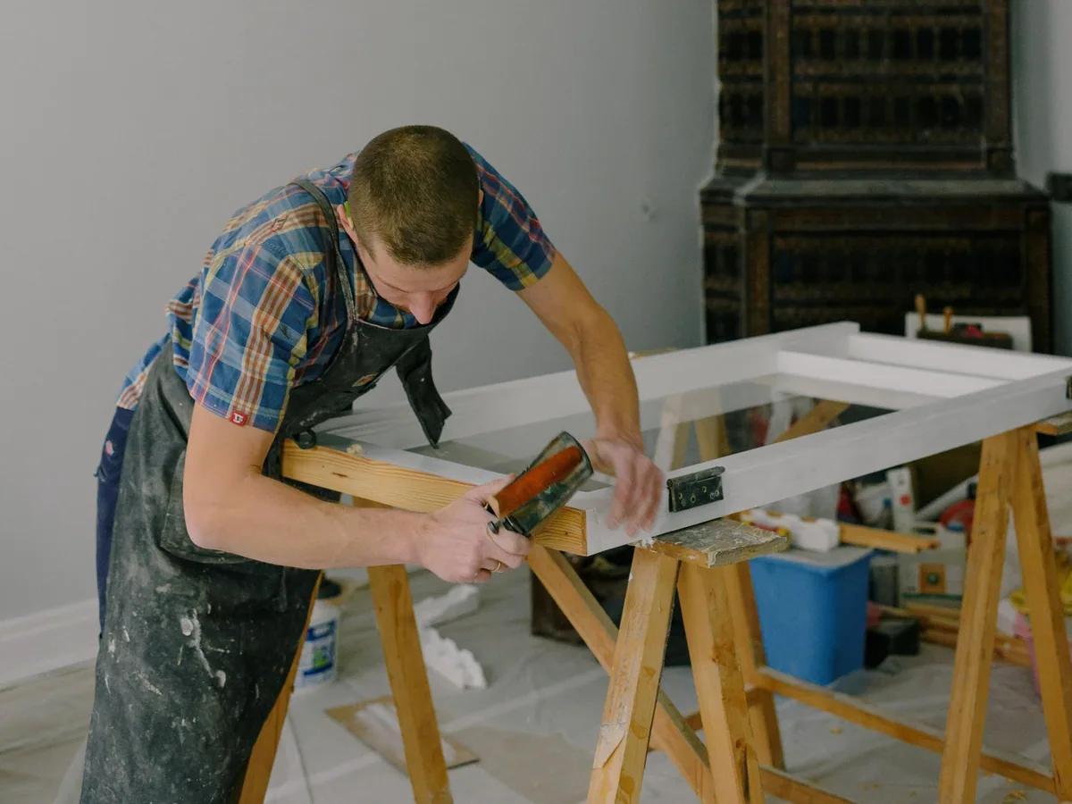 Craftsperson repairing a wooden window frame